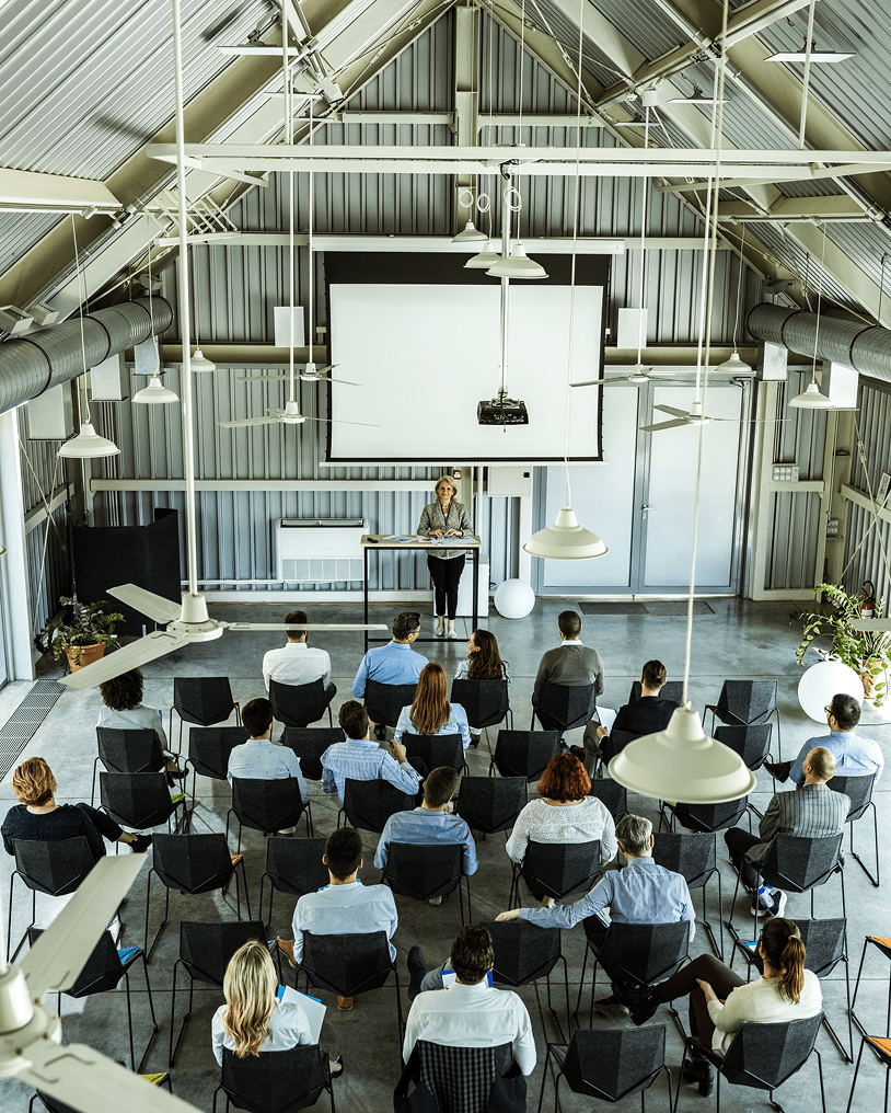 Audience listening to speaker in industrial venue